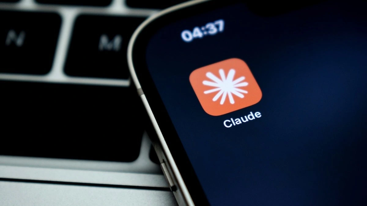 آیکون اپلیکیشن Claude متعلق به Anthropic روی نمایشگر گوشی در کنار صفحه‌کلید